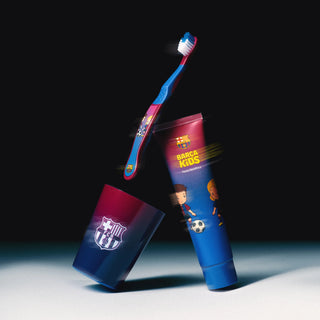 Set pentru copii FC Barcelona, incluzand periuta de dinti, pahar mov si pasta de dinti, pe fundal inchis