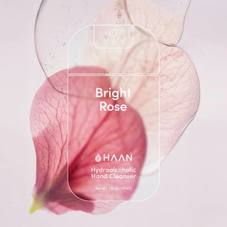 HAAN Bright Rose Hydroalcoholic Hand Cleanser bottle shown with a transparent bottle outline overlay, set against a soft pink rose petal background.