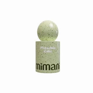 A speckled light green ceramic coffee cup with a matching spherical lid, labeled 'Pistachio Cake' and 'mimani', on a solid white background.