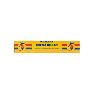 A yellow rectangular box of Tricolor Cream of the Day (Crema de Ras) featuring blue and red soccer player graphics on a white background.