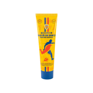 A yellow squeeze tube of dental paste with a blue cap, featuring a blue and red soccer player graphic and Romanian text, on a plain white background.