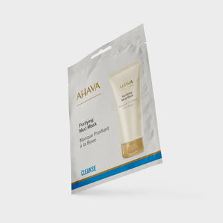 A single AHAVA Purifying Mud Mask cleansing packet shown at an angle on a light gray background. The white and gold packaging features a printed image of the mask tube and blue accent stripes near the bottom.