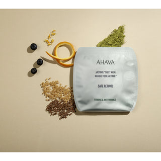 AHAVA Safe Retinol Pretinol Sheet Mask in a silver pouch, styled on a beige background with blueberries, matcha green powder, oats, and a citrus peel slice.