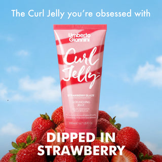 Umberto Giannini Curl Jelly strawberry scrunching jelly in a pink tube, surrounded by fresh strawberries against a blue sky background, with promotional text overlays.