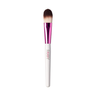 A makeup brush with a white handle, a metallic pink ferrule, and brown-to-cream bristles. The brand name 'RUBY' is printed vertically on the handle.