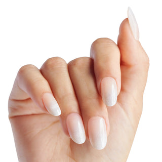 A close-up of a hand with long, almond-shaped nails styled in a glossy white ombre gradient, set against a solid white background.