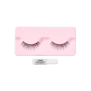 A pair of false eyelashes displayed on a pink rectangular tray, with a small white tube of KISS Temporary Eyelash Color placed below the tray, all on a plain white background.