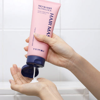 Hand holding a pink hair mask tube labeled 'Trimay' with white background