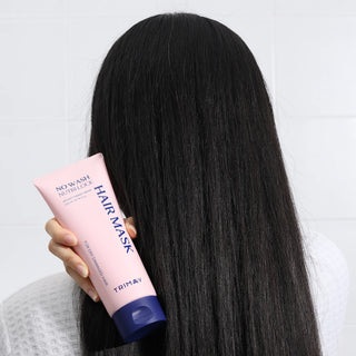 Person holding a pink hair mask with long black hair against a light background