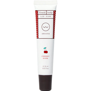 A 15 ml squeeze tube of frank body Cherry Bomb Lip Tint. The tube is white with a dark brown cap, featuring red and black text and graphics including a small cherry illustration.