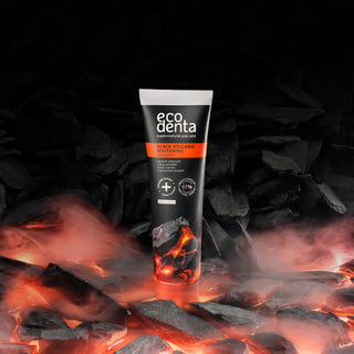 Tub de pasta de dinti Ecodenta Black Whiteningcu, pe fundal de roca vulcanica