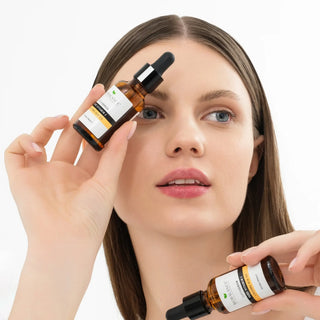 Femeie tinand in mana doua sticlute ser Biobalance cu vitamina C, pe fundal alb